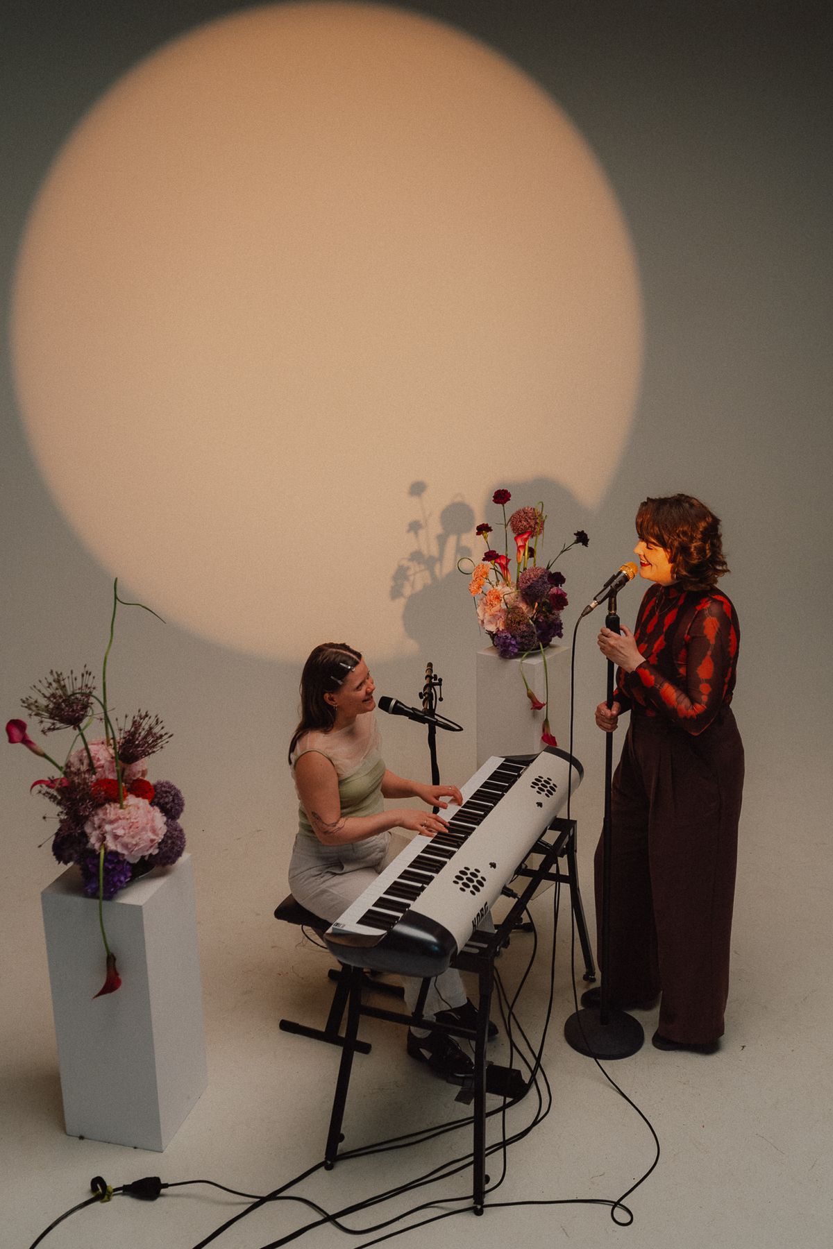 Pianistin und AVA vor einem runden Lichtkegel